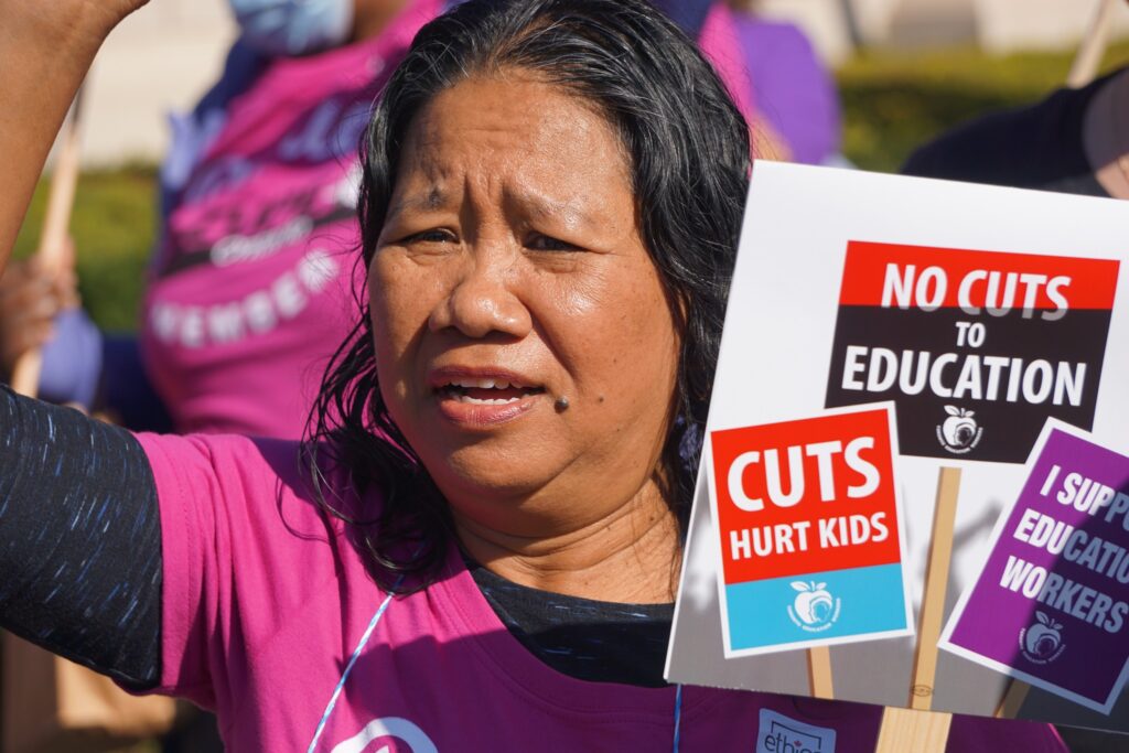 Woman at rally supporting education workers.
