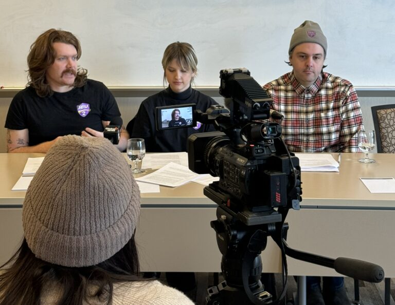 Cailen Pygott, Emily “Em K” Kristensen, and Andy Mawko. sitting at a table during a press conference.