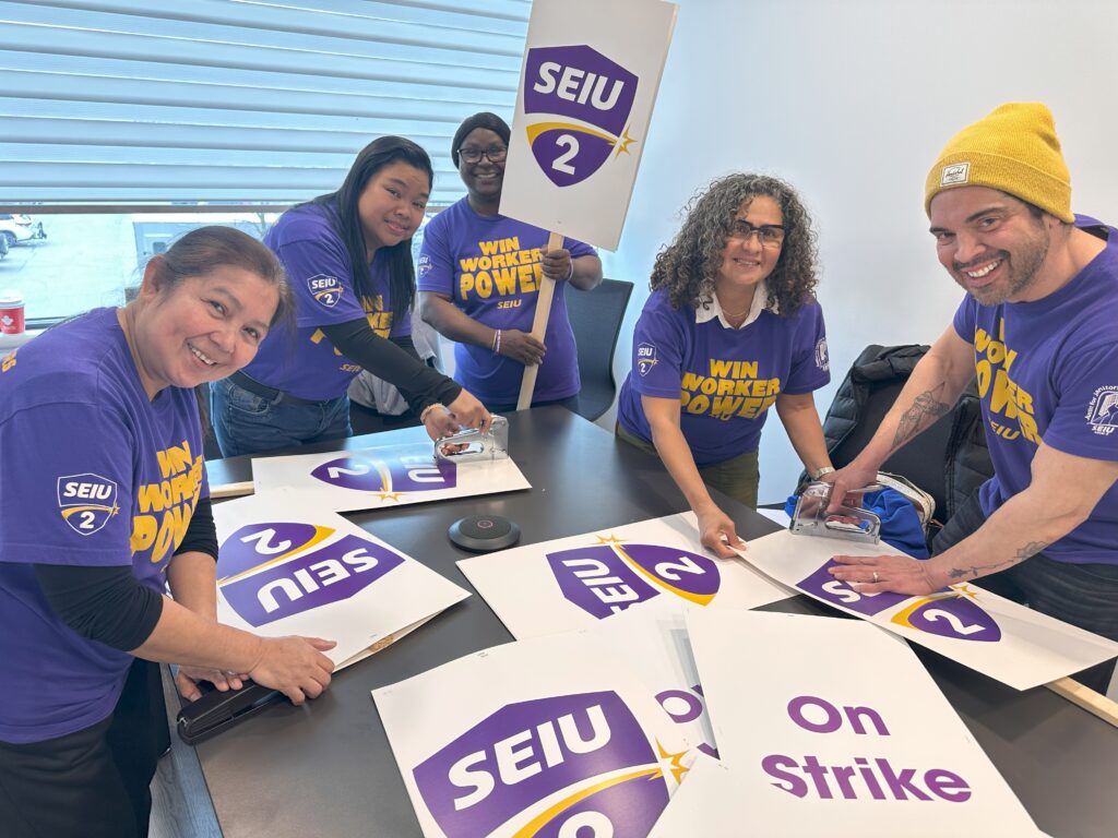 Members of the J4J Toronto bargaining committee start preparing picket signs.