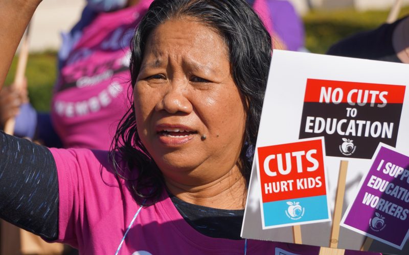 Woman at rally supporting education workers.